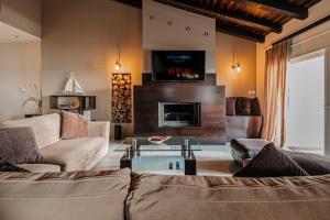 a living room with a couch and a fireplace at Sunset Beach House in Agios Georgios