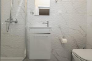 a bathroom with a shower and a sink and a toilet at Sunset Beach House in Agios Georgios +26 photos