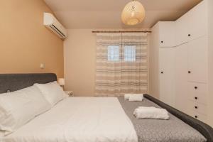 a bedroom with a large white bed and a window at Sunset Beach House in Agios Georgios