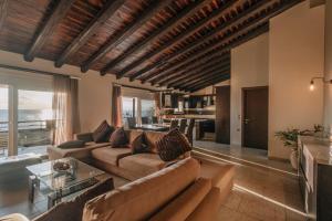 a living room with a couch and a table at Sunset Beach House in Agios Georgios