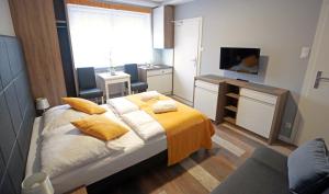 a bedroom with a bed with yellow pillows on it at Pod Różami in Grzybowo +18 photos
