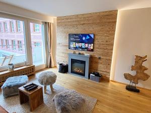 ein Wohnzimmer mit einem Kamin und einem TV in der Unterkunft Alpenstil, 4 Pax, zentral, 1 Parkplatz - RE31 in St. Moritz