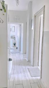 a hallway with white walls and wooden floors and a mirror at Venum in Varna City