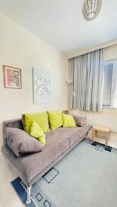 een woonkamer met een bank met gele kussens bij Venum in Varna