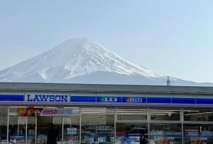 a snow covered mountain behind a store in front of a building at TOCORO. Mt.Fuji The Airstream Kawaguchiko Station in Azagawa