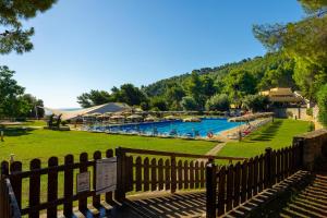 a fence in front of a pool with a resort at Pugnochiuso Resort Villette Belvedere in Pugnochiuso