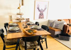 a dining room table with chairs and a deer on the wall at Alpenstil, 4 Pax, zentral, 1 Parkplatz - RE31 in St. Moritz