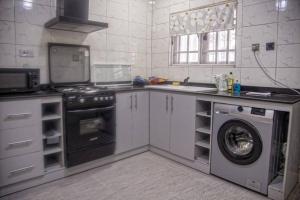 a kitchen with a stove and a washing machine at TFP Lodge in Ibadan