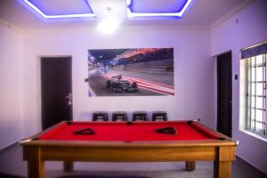 un tavolo da biliardo rosso in una stanza con una foto sulla parete di TFP Lodge a Ibadan