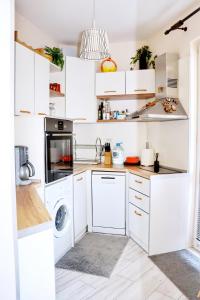 a kitchen with white cabinets and a washer and dryer at Venum in Varna City
