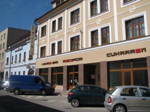 two cars parked in front of a building at Hotel Academic in Zvolen