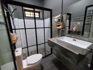 uma casa de banho com um lavatório e um WC em Tanwa Hotel em Chiang Mai