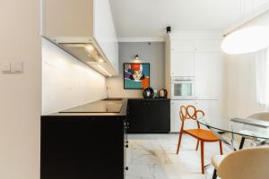 eine Küche mit schwarzen Schränken und einem Glastisch in der Unterkunft Apartament Nowolipki z sypialnią in Warschau