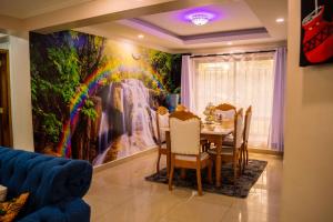 a dining room with a painting of a waterfall at The Fancy Luxurious 3 bedroom apartment in Nakuru
