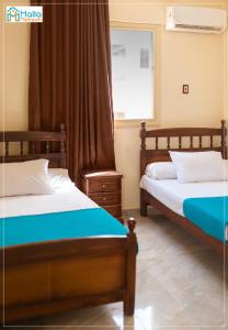 1 dormitorio con 2 camas y ventana en Halla Matrouh, en Marsa Matruh
