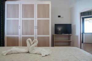 a bedroom with a bed with a towel animal on it at Il Poggio Di Tropea in Parghelia