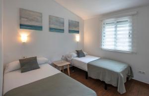 A bed or beds in a room at Apartamentos Los Rosales