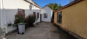 un callejón entre dos edificios con un cubo de basura al lado en Pensión al sur del.mundo en Punta Arenas