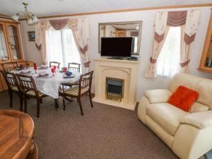 a living room with a table and a fireplace at Park Lane in Narberth