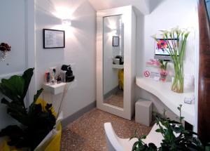 a bathroom with a sink and a mirror and plants at Il Piccolo Rooms in Pontedera