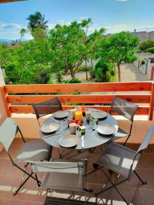 un tavolo e sedie seduti su un balcone di Les Cigalines a Saint-Cyprien-Plage