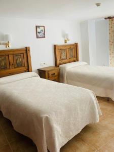 1 dormitorio con 2 camas y armarios de madera en Apartamentos Balcon de Carabeo en Nerja