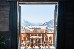a balcony with chairs and a view of the mountains at Hotel Farinet in Verbier