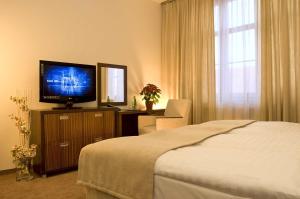 a bedroom with a bed and a flat screen tv at Hotel Academic in Zvolen