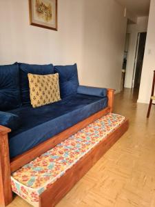 un sofá azul sentado en una sala de estar en Departamento Playa Bristol Casino en Mar del Plata