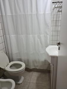 a bathroom with a white shower curtain and a toilet at Departamento Playa Bristol Casino in Mar del Plata
