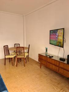a living room with a table and a tv at Departamento Playa Bristol Casino in Mar del Plata