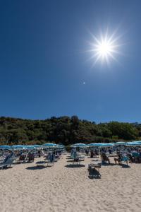 grupa leżaków i parasoli na plaży w obiekcie Il Poggio Di Tropea w mieście Parghelia