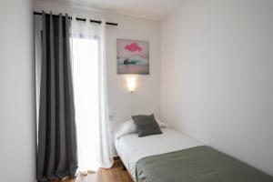A bed or beds in a room at Apartamentos Los Rosales