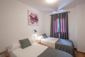 A bed or beds in a room at Apartamentos Los Rosales Még 37 kép