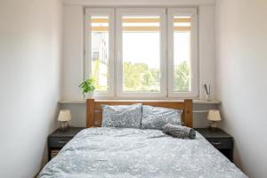 a bedroom with a large bed with two windows at The Best Location in Cracow for City Break in Kraków