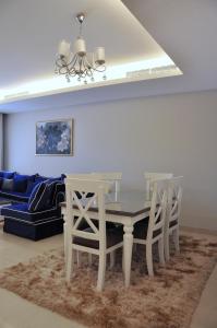a dining room table with two chairs and a couch at Axxodia Cairo Festival Residence in Cairo