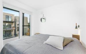 ein weißes Schlafzimmer mit einem Bett und einem großen Fenster in der Unterkunft Cozy Apartment In Lembruchdümmer See in Lembruch