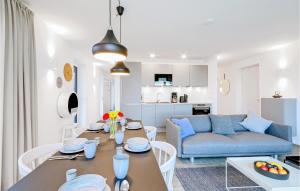 ein Wohnzimmer mit einem Tisch und einem blauen Sofa in der Unterkunft Cozy Apartment In Lembruchdümmer See in Lembruch