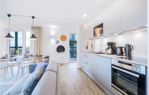 eine Küche und ein Wohnzimmer mit einer Couch und einem Tisch in der Unterkunft Cozy Apartment In Lembruchdümmer See in Lembruch + 25 Fotos