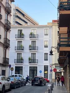a white building with cars parked in front of it at Amazinn Places EVIapartments in Valencia