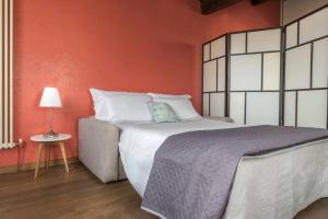een slaapkamer met een groot bed met een oranje muur bij enJoy Home - Mansarda nel cuore di Padova in Padua