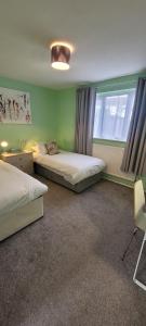 a bedroom with two beds and a window at Rent Unique the Beeches 2bed in Crawley