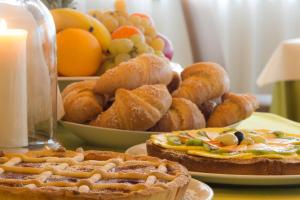 une table recouverte de assiettes de pâtisseries et de fruits dans l'établissement Hotel Eurorest, à Conegliano