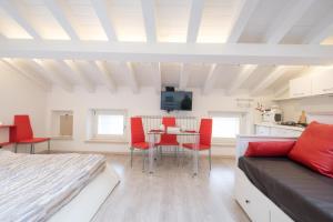 a bedroom with a bed and a table with red chairs at Ca' Del Jago Sole Luna apartment in Negrar +36 photos