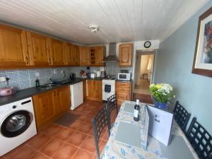 a kitchen with wooden cabinets and a table with chairs at Maggie's Cottage in Thurles