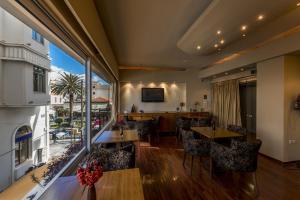 um restaurante com mesas e cadeiras e uma grande janela em Lakonia Hotel em Sparti