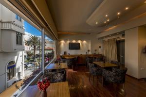 a restaurant with tables and chairs and a large window at Lakonia Hotel in Sparta