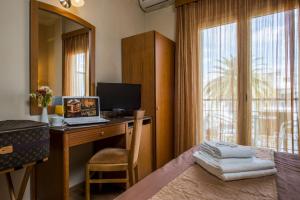 a bedroom with a desk with a computer and a window at Lakonia Hotel in Sparta