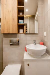 a bathroom with a white sink and a toilet at The Best Location in Cracow for City Break in Kraków