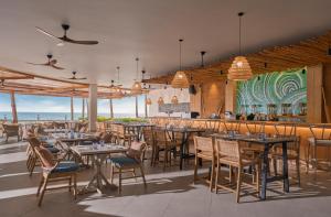 a restaurant with tables and chairs and the ocean at Boma Resort Nha Trang in Nha Trang